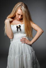 Portrait of the beauty young blond girl in white dress