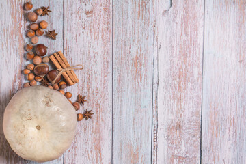  Autumn flatlay with pumpkin, chestnuts, star anise, cinnamon and cobnuts on a white wooden...