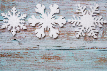  Three white snowflakes on a blue wooden background topview. New Years flatlay with copyspace