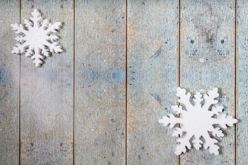Two snowflakes on a light blue wooden background. Christmas winter flatlay with copyspace