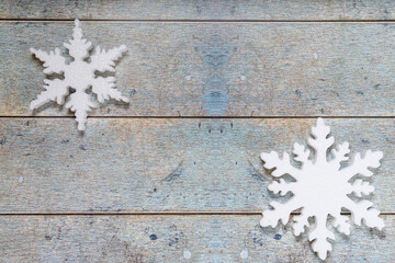Two snowflakes on a light blue wooden background. Christmas winter flatlay with copyspace