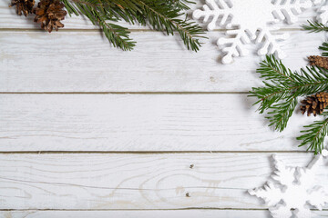 Topview of pine cones, branches, snowflakes, decoration balls on wooden  white background. Christmas flatlay with copyspace
