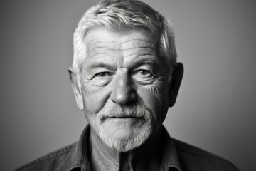 Portrait of a senior man on a grey background. Black and white.