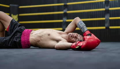 Unconscious Asian boxer lay on floor referee countdown knockout in fighting ring at fitness gym. Boxing is fighter sport training need body muscular strength, power fist, sweating to become champion