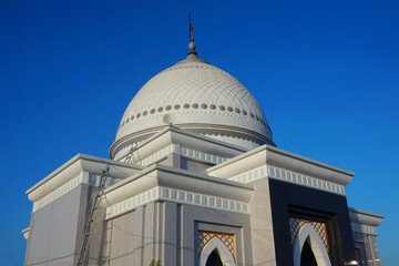 Fototapeta na wymiar Photo of an elegant white mosque under the blue sky