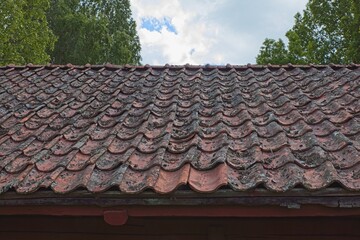 Weathered orange color shingle clay roof tiles.