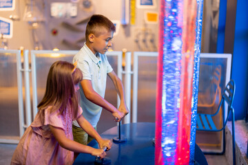 Little kids pump a bubbles into tubes studying physical phenomena in an interactive way, visiting...