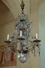 Chrystal chandelier hanging from roof of a church.