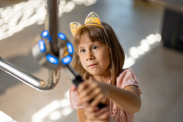 Little girl studying physics and electricity on an interactive model in the science museum. Concept...