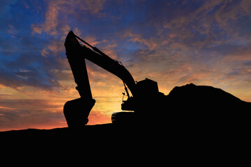 Crawler excavators silhouette are digging the soil in the construction site on the sunset background