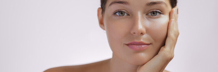 Skincare. Woman with beautiful face touching healthy facial skin. Fascinating portrait of confident...