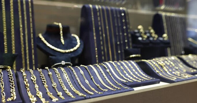 Expensive jewelry on counter of jewelry store. Various diamonds sapphires gold earrings bracelets, rings necklaces on sale