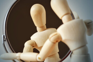 Wooden mannequin looking at himself in the mirror - Concept of interiority, introspection and...