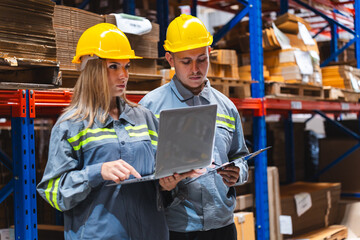 Paper and cardboard factory warehouse workers using a digital tablet while recording inventory....