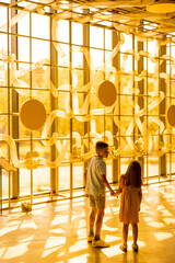 Little boy and girl standing together and looking at the installation in the science museum. Concept of children's entertainment and learning