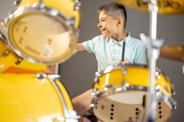 Little boy playing on a real drums, having fun while visiting a science museum