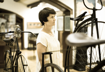 Mature woman examines the exhibit in museum