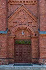 Fototapeta na wymiar Old wooden door on a brick church.