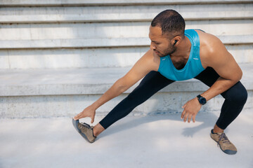 Male athlete doing legs workout and squats on the stairs