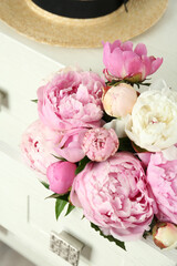 Bouquet of beautiful peonies in commode drawer indoors