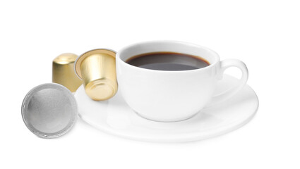 Cup of coffee and capsules isolated on white