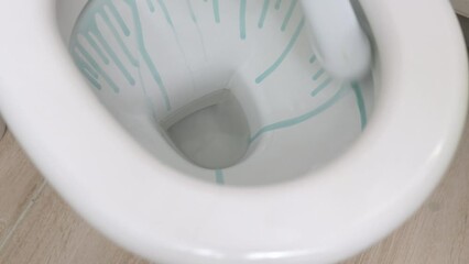 Toilet cleaning and disinfection. Unrecognizable woman hands in protective rubber gloves pour disinfectant into the toilet