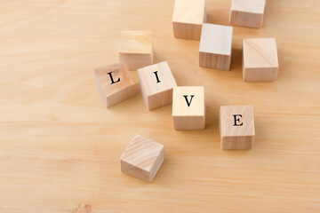 Obraz premium creative composition. on a light table lie small wooden cubes with the inscription live, creative concept