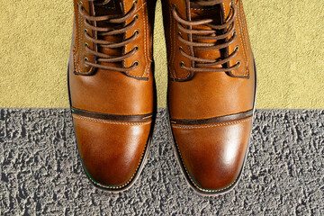 A pair of premium calfskin boots on a stone background. Horizontal shot.