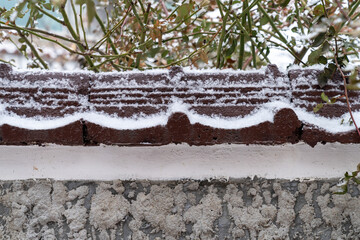 snow on the wall, snowflakes perched on the fence.