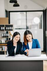 Asian business colleague business presents and explains and using laptop and tablet. Teamwork, financial marketing team