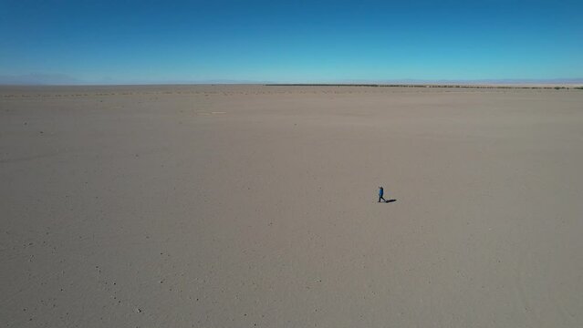 Beautiful aerial footage of the a person walking alone in the Atacama Dessert - Calama - Antofagasta Dessert and Salar - turquoise lagoon.