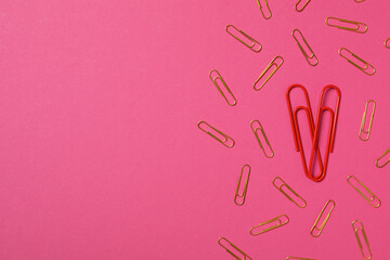 Heart from paper clips, on a red background.