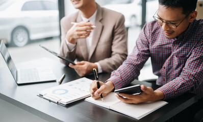 Obraz premium Businessman and team analyzing financial statement Finance task. with smart phone and laptop and tablet. .