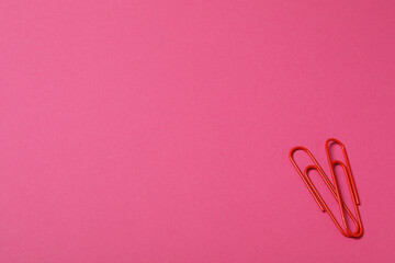 Heart from paper clips, on a red background.