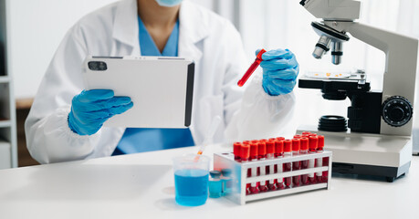 Fototapeta premium Female scientist researcher conducting an experiment working in the laboratory