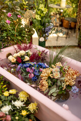 Fototapeta na wymiar Colorful cut flowers in pink bathtub with water. Lots of blooming flowers, flower therapy and beauty concept
