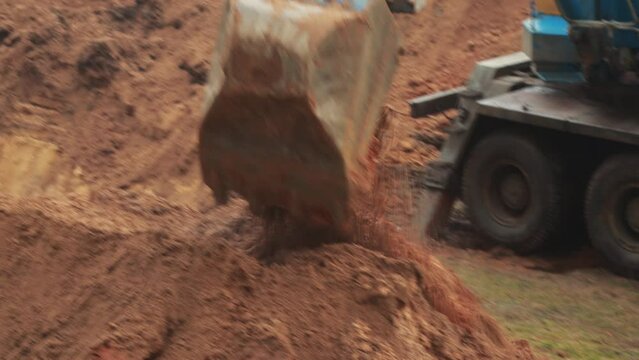 Swivel bucket with a retractable telescopic boom in a car excavator. Earthmoving, close-up. Industry