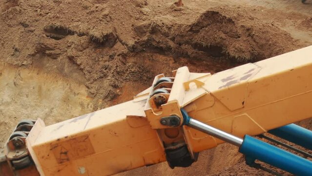 A modern excavator with a rotary bucket and a telescopic boom digs a hole, transfers soil. Industry