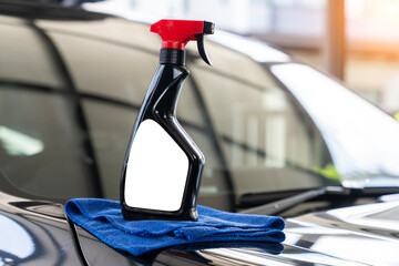 A bottle of car wax placed on the car's hood