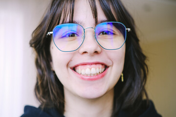 Close-up portrait of a pretty young brunette woman with eyeglasses casually dressed