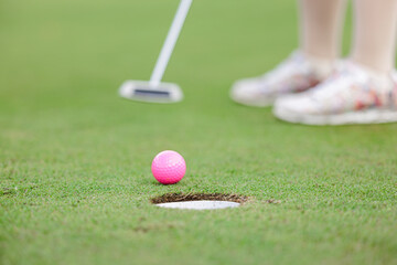 woman golfer teeing golf in golf tournament competition at golf course, selective focus on golf ball,