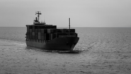 black and white logistic cargo container ship sailing in sea