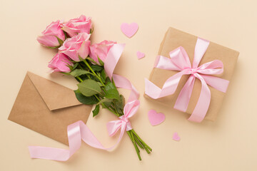 Pink roses with hearts and gifts on color background, top view. Valentines day concept