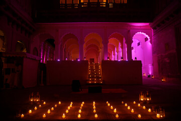 Beautiful decor with glass flasks, candles, and lanterns for a royal Indian wedding ceremony at...