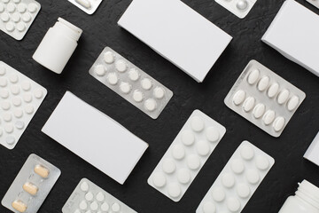 Different pills in blister packaging and boxes and on concrete background, top view