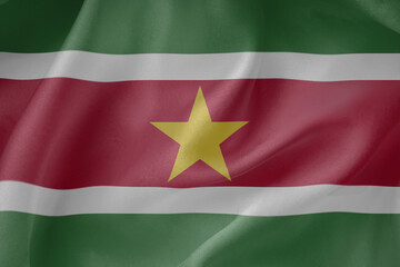 Suriname waving flag close up fabric texture background