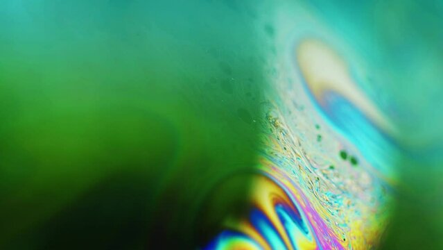 Paint swirl. Ink mix water. Psychedelic illusion. Defocused neon green yellow pink cyan blue color fluid blend wave motion on dark abstract art free space background.