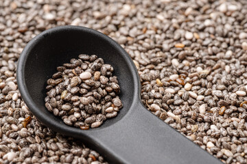 Spoon of chia seeds over chia seeds. Food background.