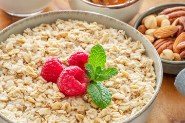 Bowl of porridge or oatmeal with fruits close up. Breakfast concept.