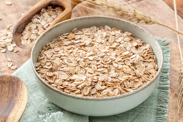 Bowl of wheat flakes on wooden table. Top view. Rural concept.